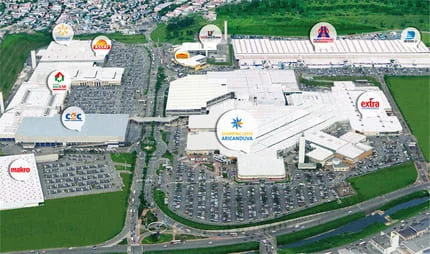 Área do Shopping Aricanduva mostrando a entrada principal com fachadas de lojas e estacionamento amplo.