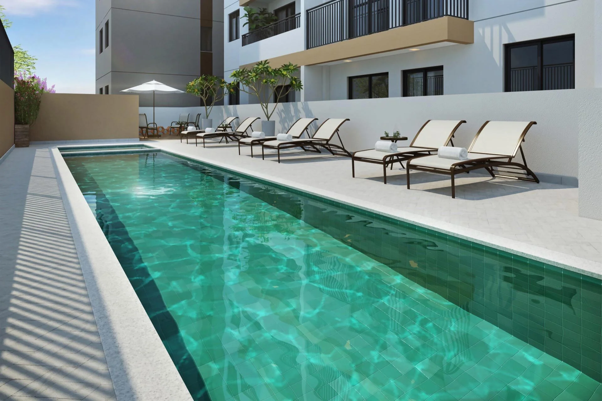 Piscina ampla com espreguiçadeiras ao redor.